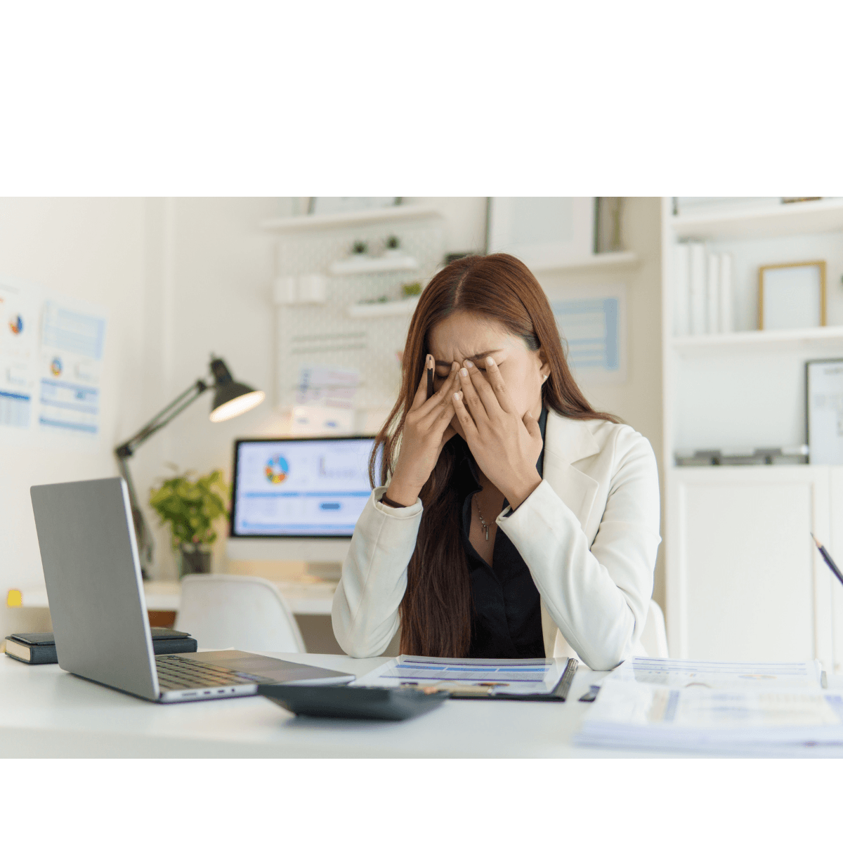 Image of an office worker in front of a laptop, feeling stressed